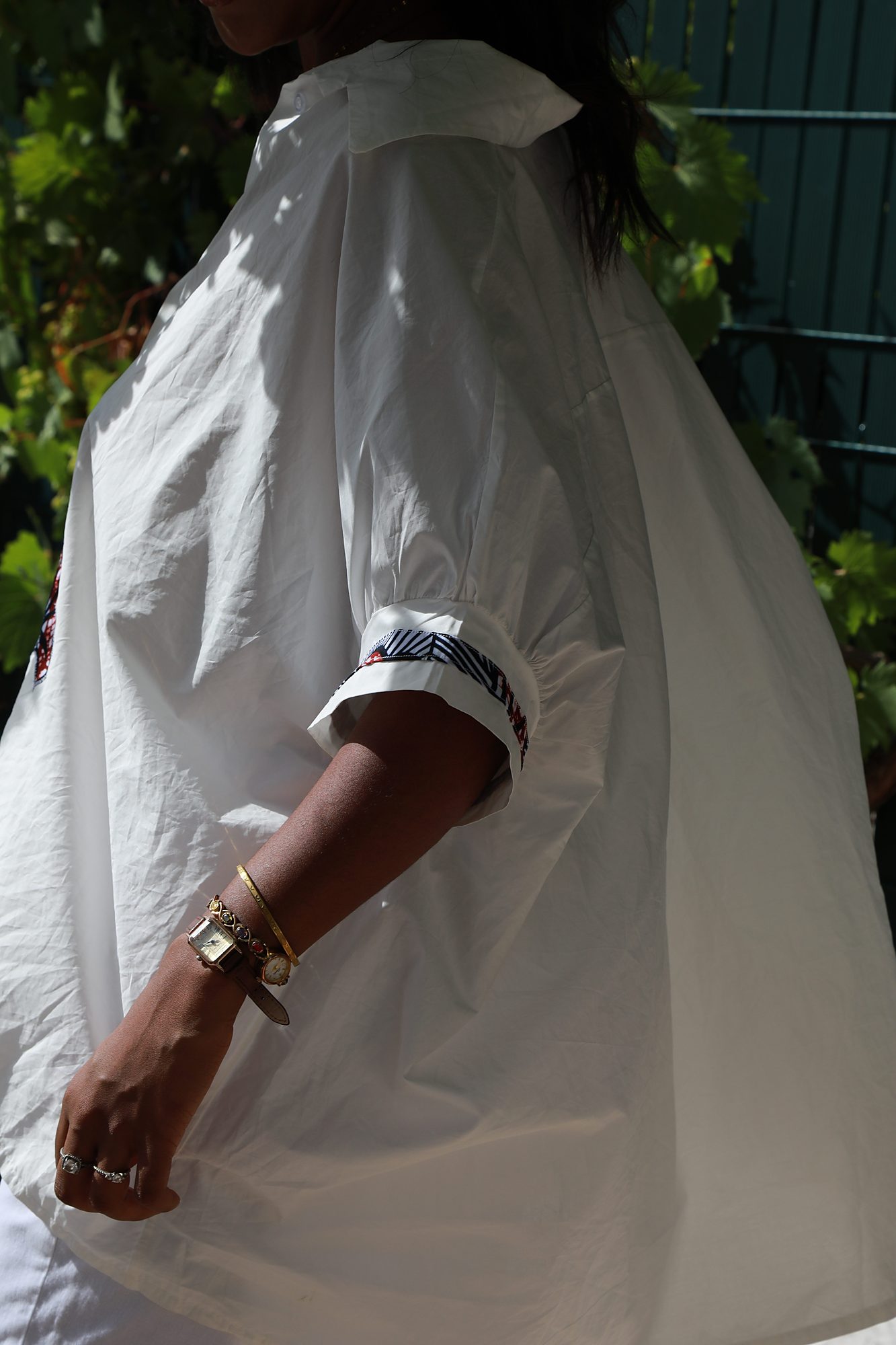 Gros plan des détails floraux en tissu wax de la chemise oversize Camille, soulignant les finitions artisanales et le savoir-faire de l'atelier Princesse Couture.
