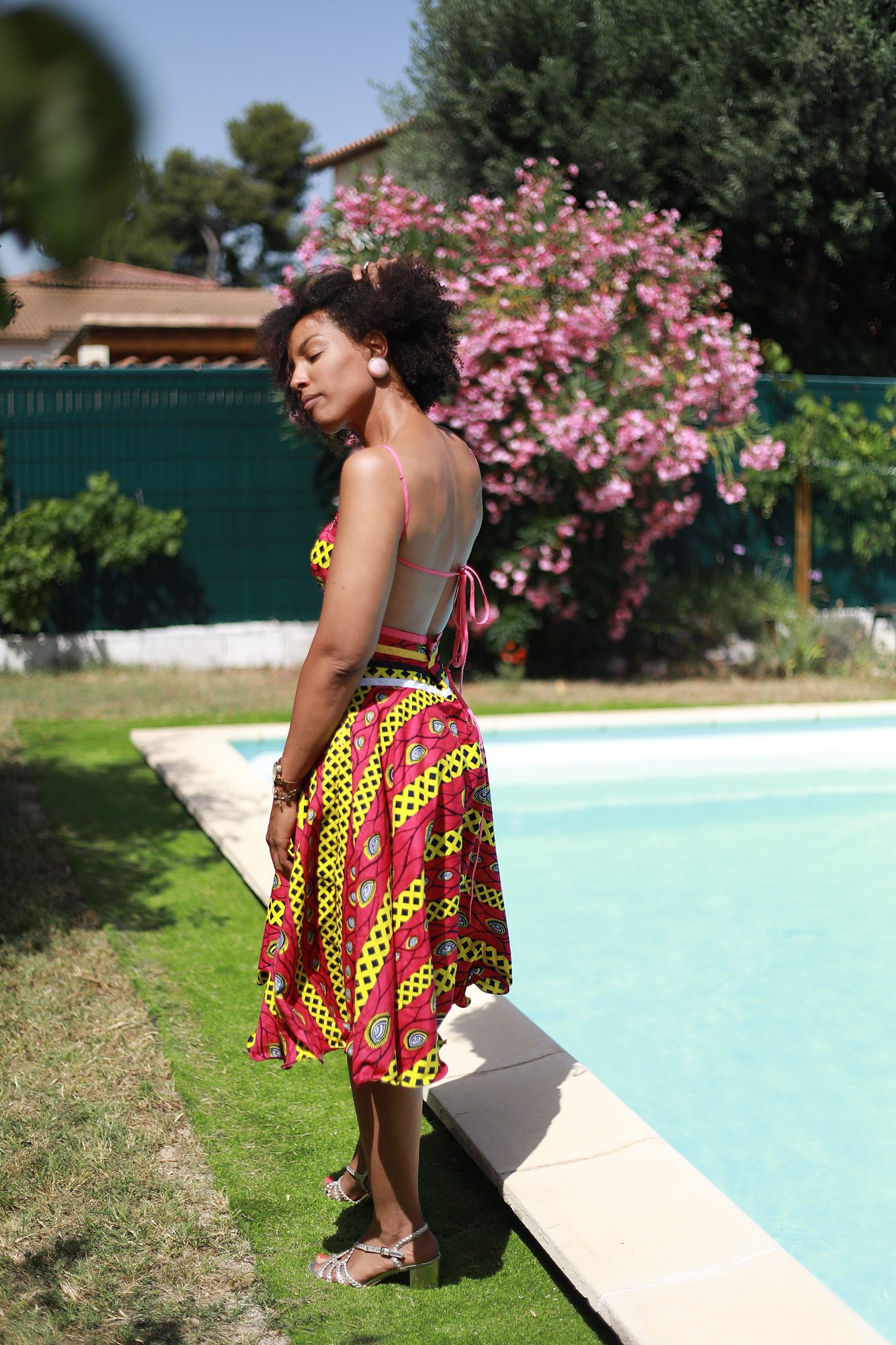 Vue de dos de la robe Rina sur mesure, mettant en valeur son dos élégant, sa coupe évasée et son tissu wax coloré réalisé artisanalement chez Princesse Couture.