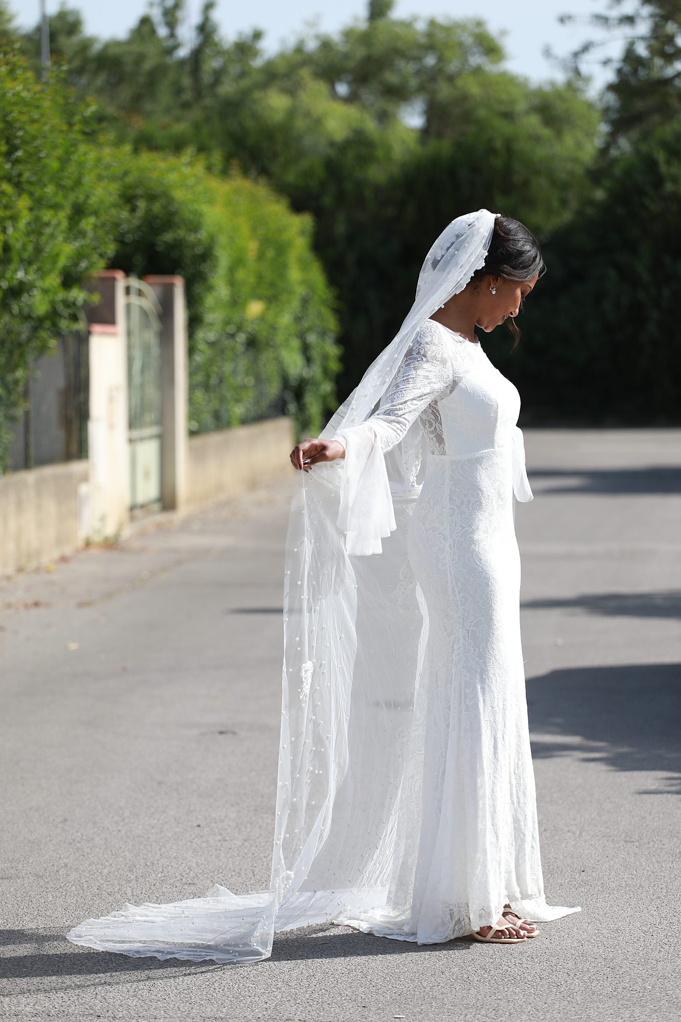 Vue d'ensemble trois-quarts de la robe de mariée Solveig sur mesure, mettant en valeur sa silhouette élégante, sa dentelle raffinée, son voile délicat et sa confection artisanale près de Montpellier.