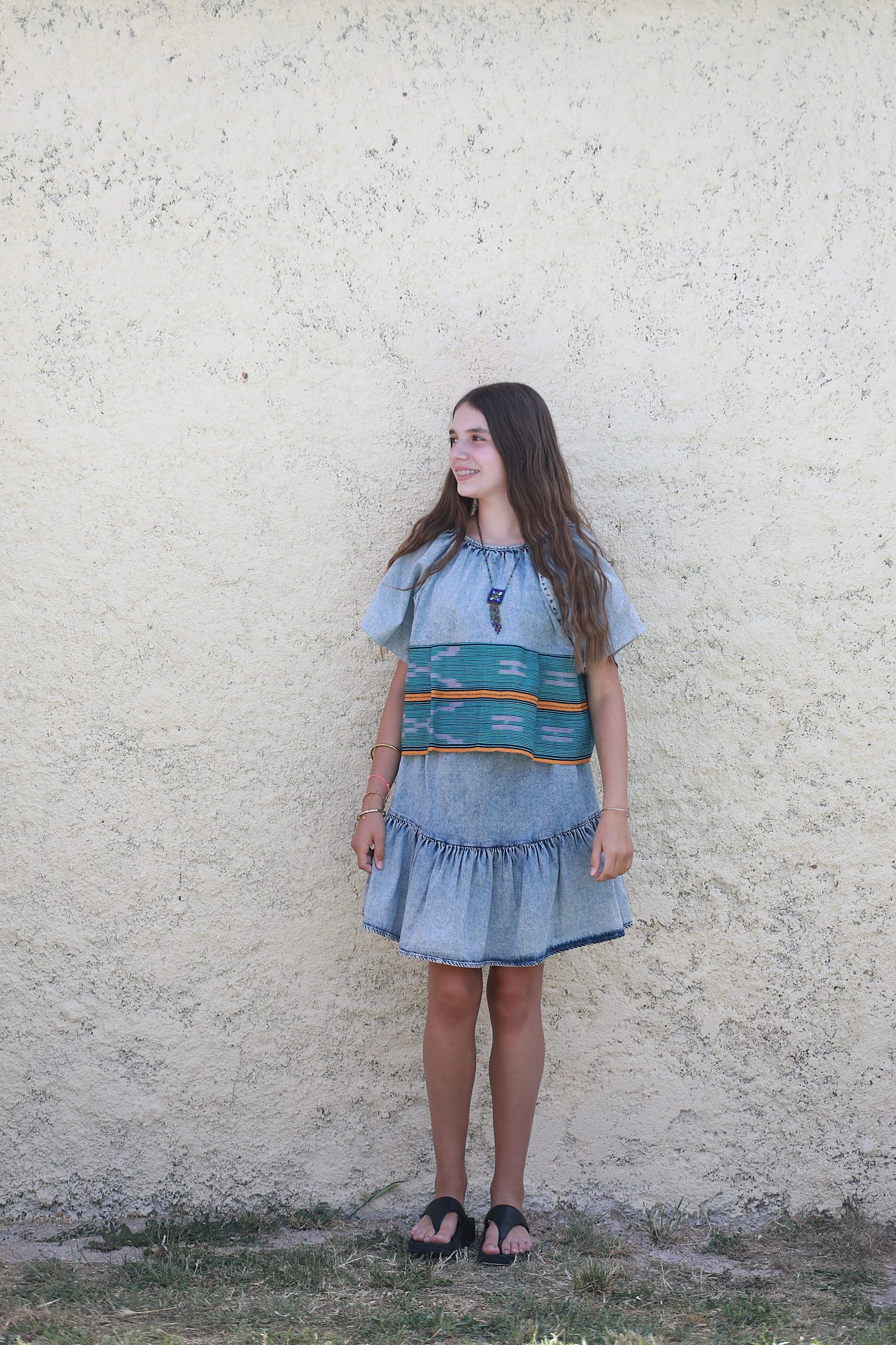 Vue de face de l'ensemble Charlotte sur mesure, composé d'un haut et d'une jupe en denim avec des détails en Pagne Baoulé traditionnel de Côte d'Ivoire, confectionné à la main dans l'atelier Princesse Couture près de Montpellier.