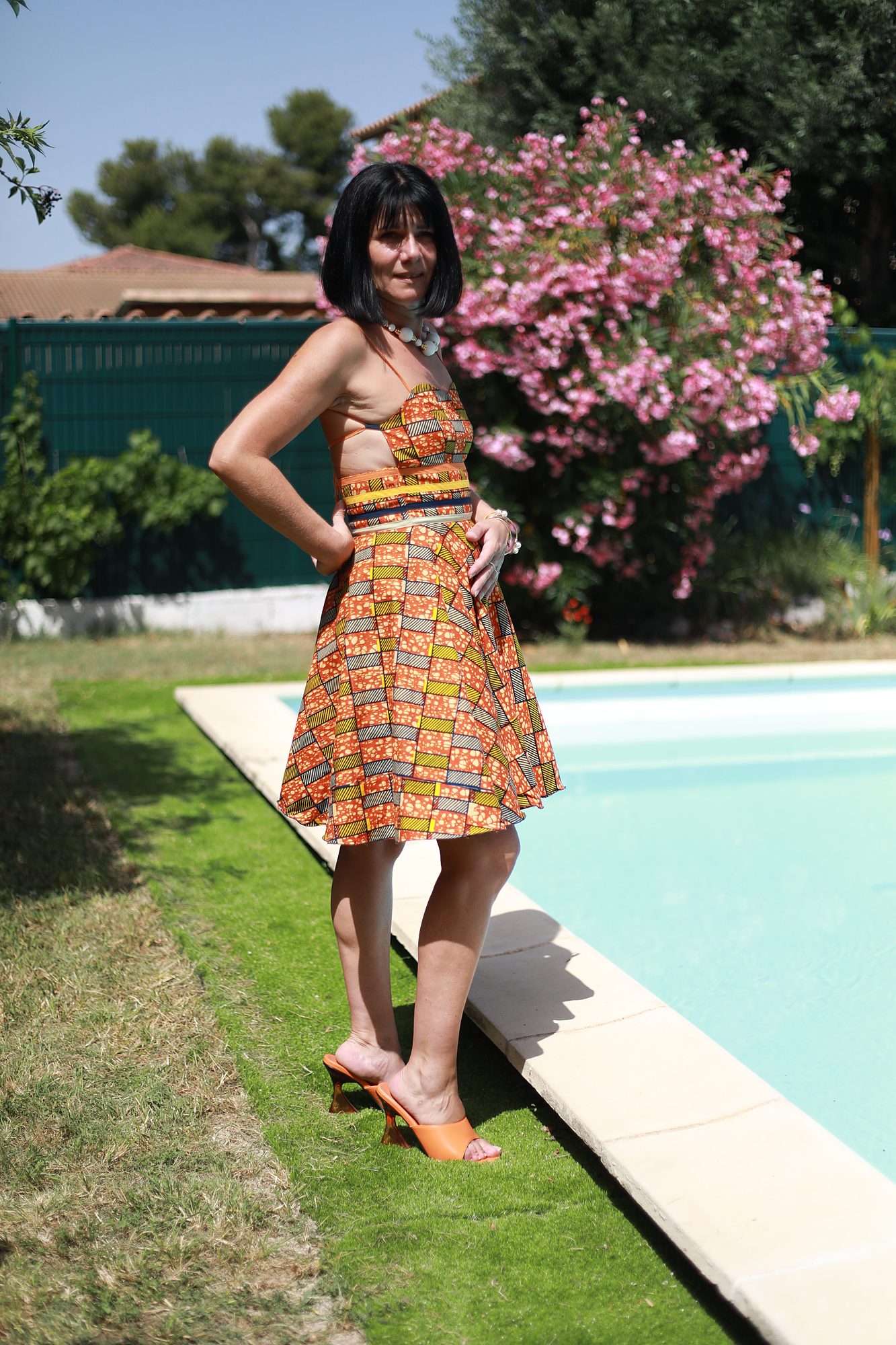 Vue de face d'une robe sur mesure en tissu wax aux motifs colorés, réalisée à la main et personnalisable avec le tissu de votre choix chez Princesse Couture.