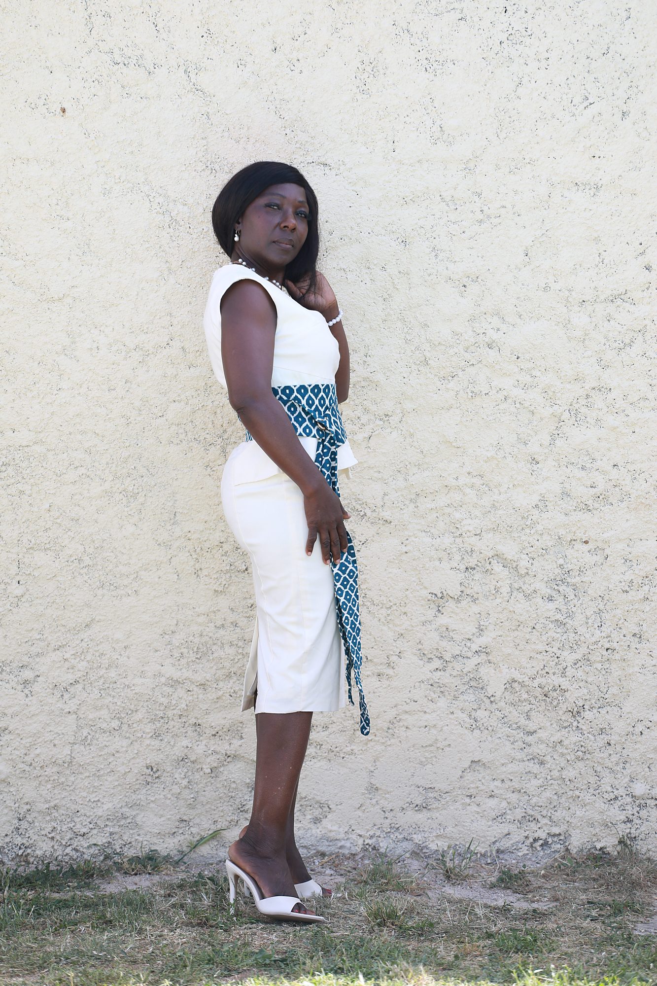 Vue d'ensemble trois-quarts de la robe Léontine sur mesure, mettant en valeur sa silhouette élégante, sa ceinture en tissu wax personnalisable et sa confection artisanale près de Montpellier.